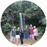 Six people standing in front of a small waterfall