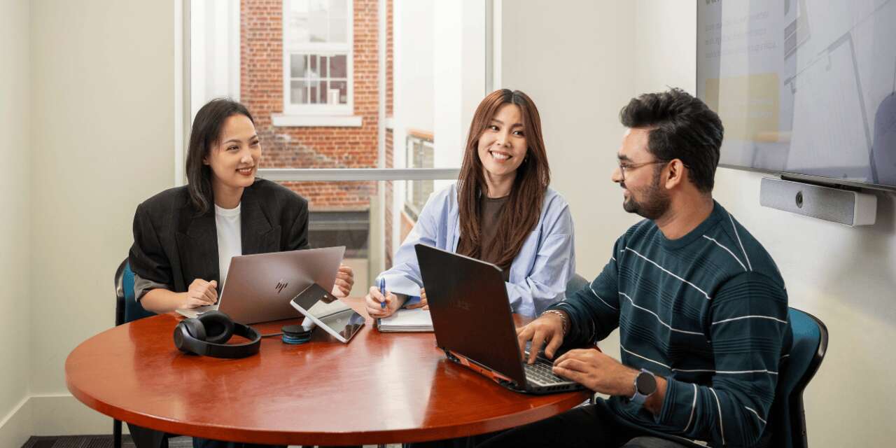 Students sitting at a table smiling and chatting