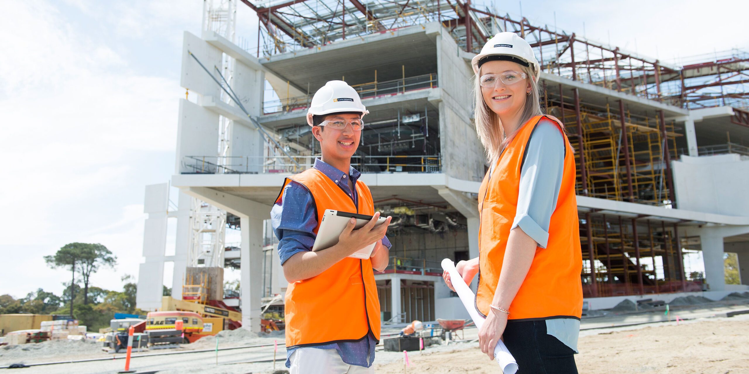 Two students on a building site wearing protective equipment