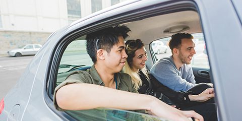 A group of student sitting in the back of a car