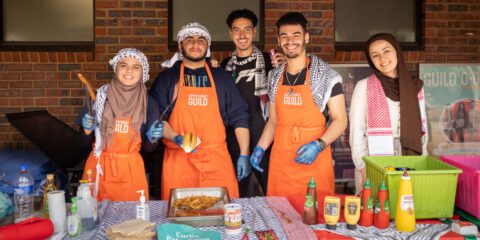 Five students serving food at a bbq stall