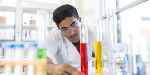 Student wearing safety glasses conducting an experiment