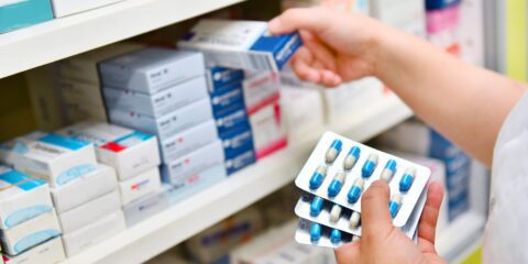 A pharmacy student holding packets of medication