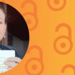 Lucy Montgomery wears a blue blazer and is smiling, she is holding a book titled