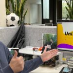 Staff member looking at the camera with thumbs up and UniSkills webpage open