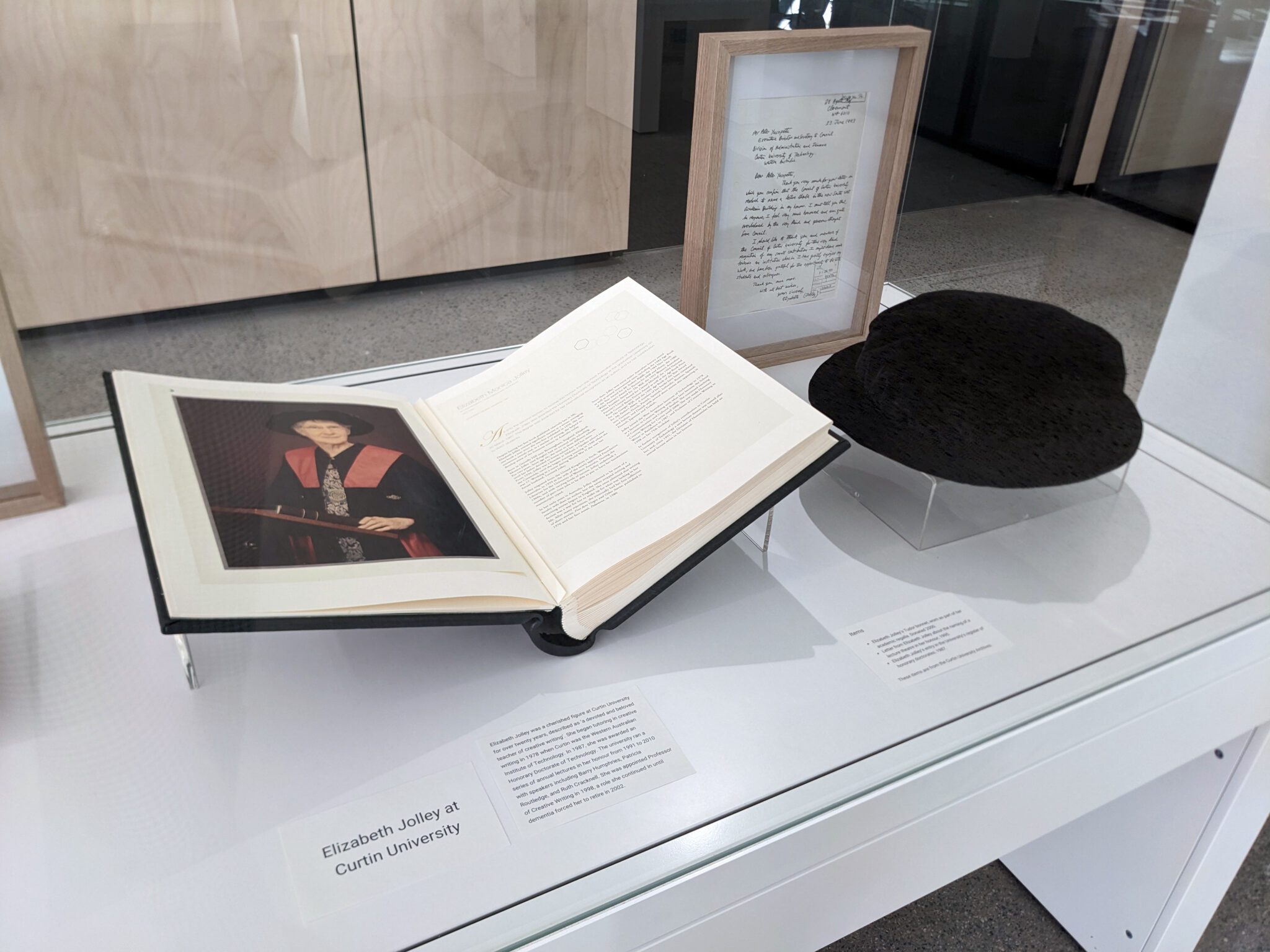 A picture of Elizabeth Jolley's Tudor bonnet, worn as part of her academic regalia, and her entry in the University's register of honorary doctorate.