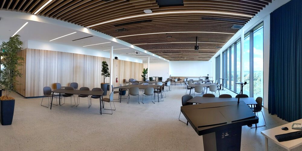Panorama view of The Lantern event space. View of lecturn, chairs and tables.