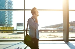 man speaking on a phone with aeroplane in the background