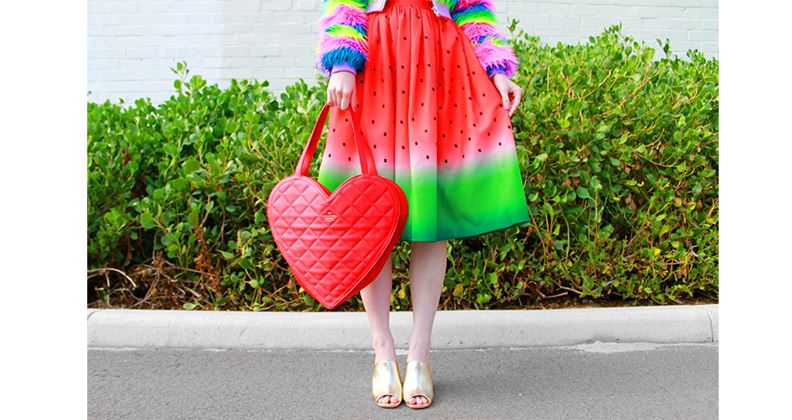 Kate Hannah in a watermelon dress and heart shaped hand bag.