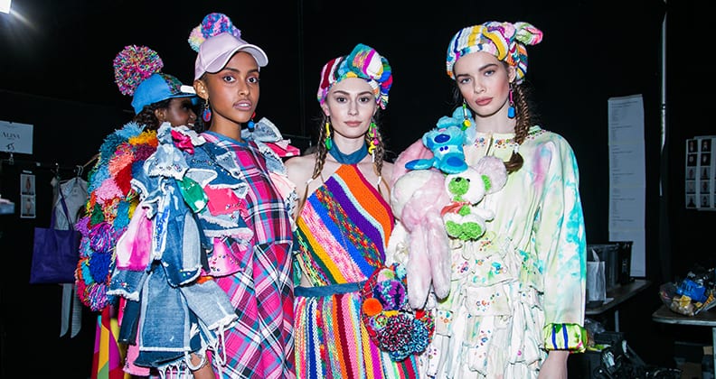 Three models wearing bright clothing made from denim, tartan, wool and toys.