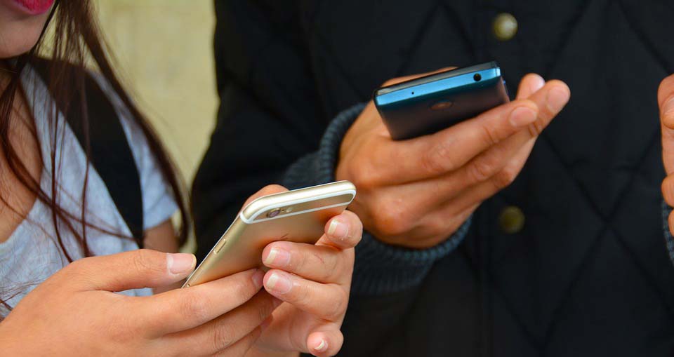 Kids texting on cell phones.