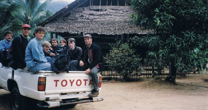 A photograph of eight young people with backpacks and camera gear are piled in the tray of a Toyota ute on the Thai-Burma border, 1992.