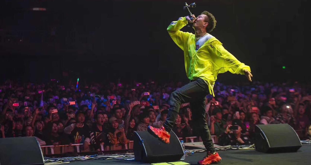Melo, from Higher Brothers, on stage in Hong Kong, singing to a crowd of fans.