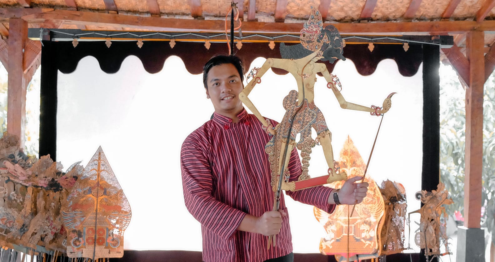 Aji Cahya Nusantara, holding a traditional Javanese shadow puppet of Bhima, a character from Mahabharata.
