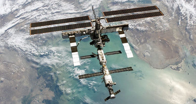 Photo of the International Space Station from space, with Caspian Sea in the background.