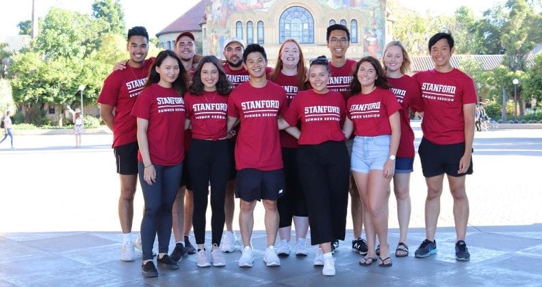 Group of students posing in Stanford tee-shirts on campus