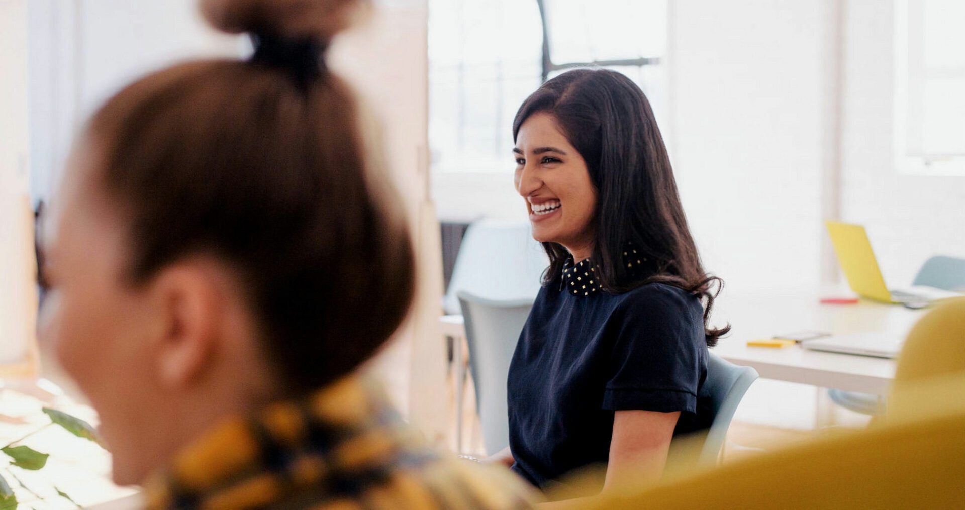 Young woman candidly smiling away at a meeting.