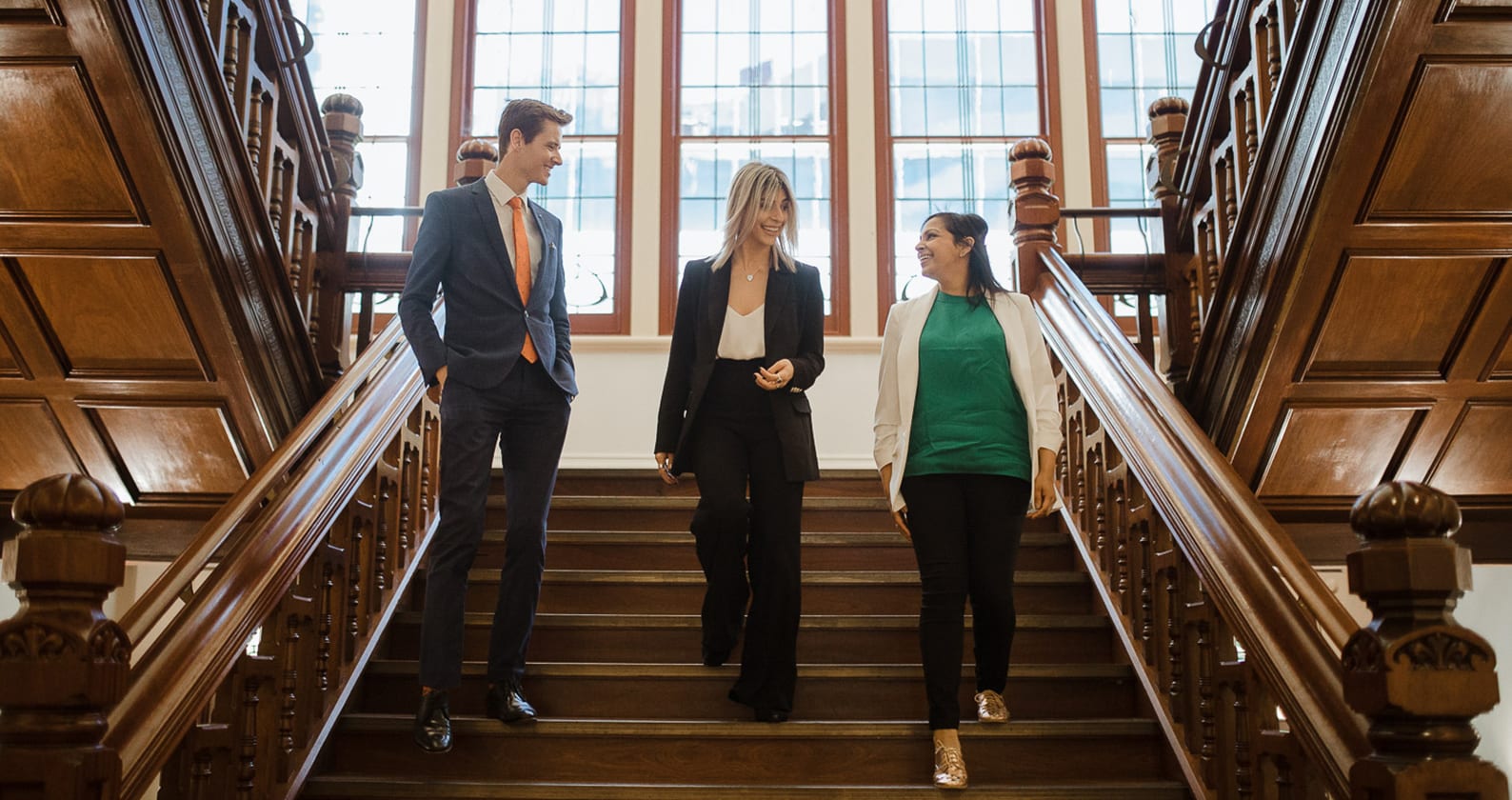 3 Curtin Law students walking down a staircase at the Curtin Law School
