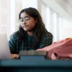 Student looking at a laptop while studying in TL Robertson Library.