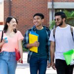 Three students walking outdoors on campus