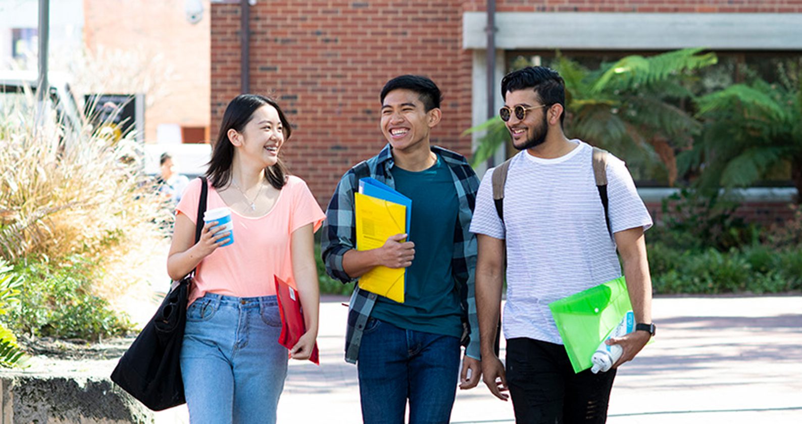 Three students walking outdoors on campus