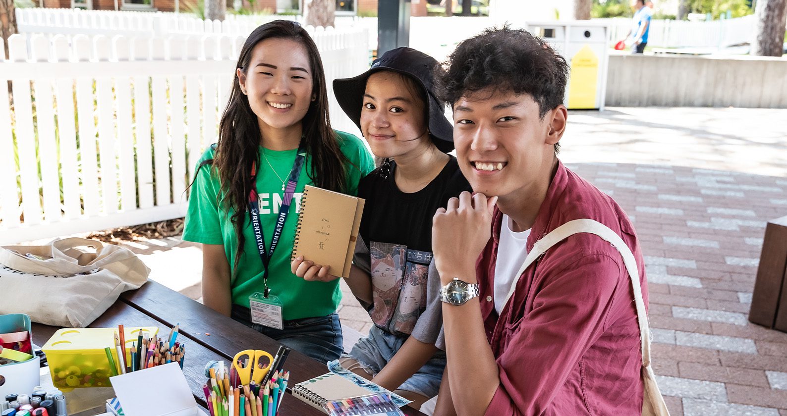 Three students sitting at a table outdoors