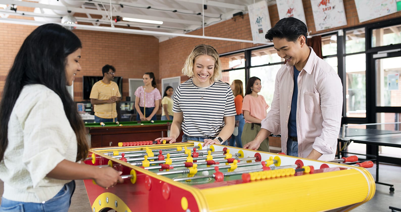 A group of students playing foosball in Curtin's accomodation facility
