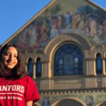 Student wearing a red Stanford t-shirt outside an historic building