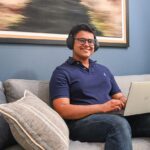 Student sitting on a sofa with a laptop.