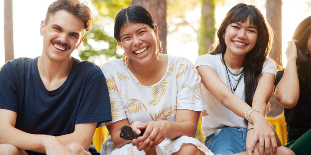 Photo of two female and one male students smiling.