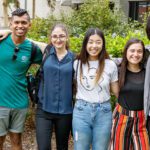 Six students standing arm-in-arm outdoors