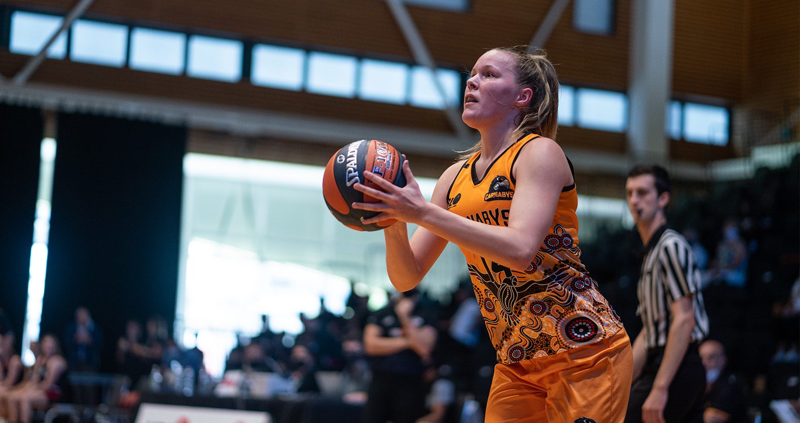 A female student on the Carnaby's basketball team preparing to throw a basketball.