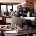 Team of programmers analyzing machine learning app code on programming big screen, standing in it company office. Software developers working on database system with html script