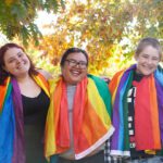 Three students with rainbow pride flags