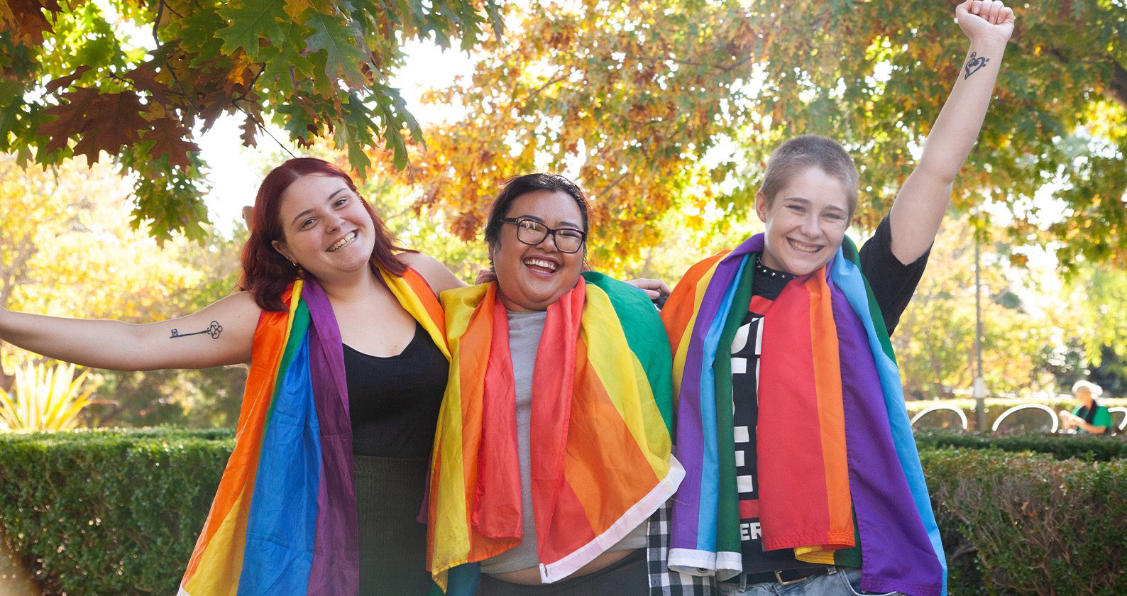 Three students with rainbow pride flags