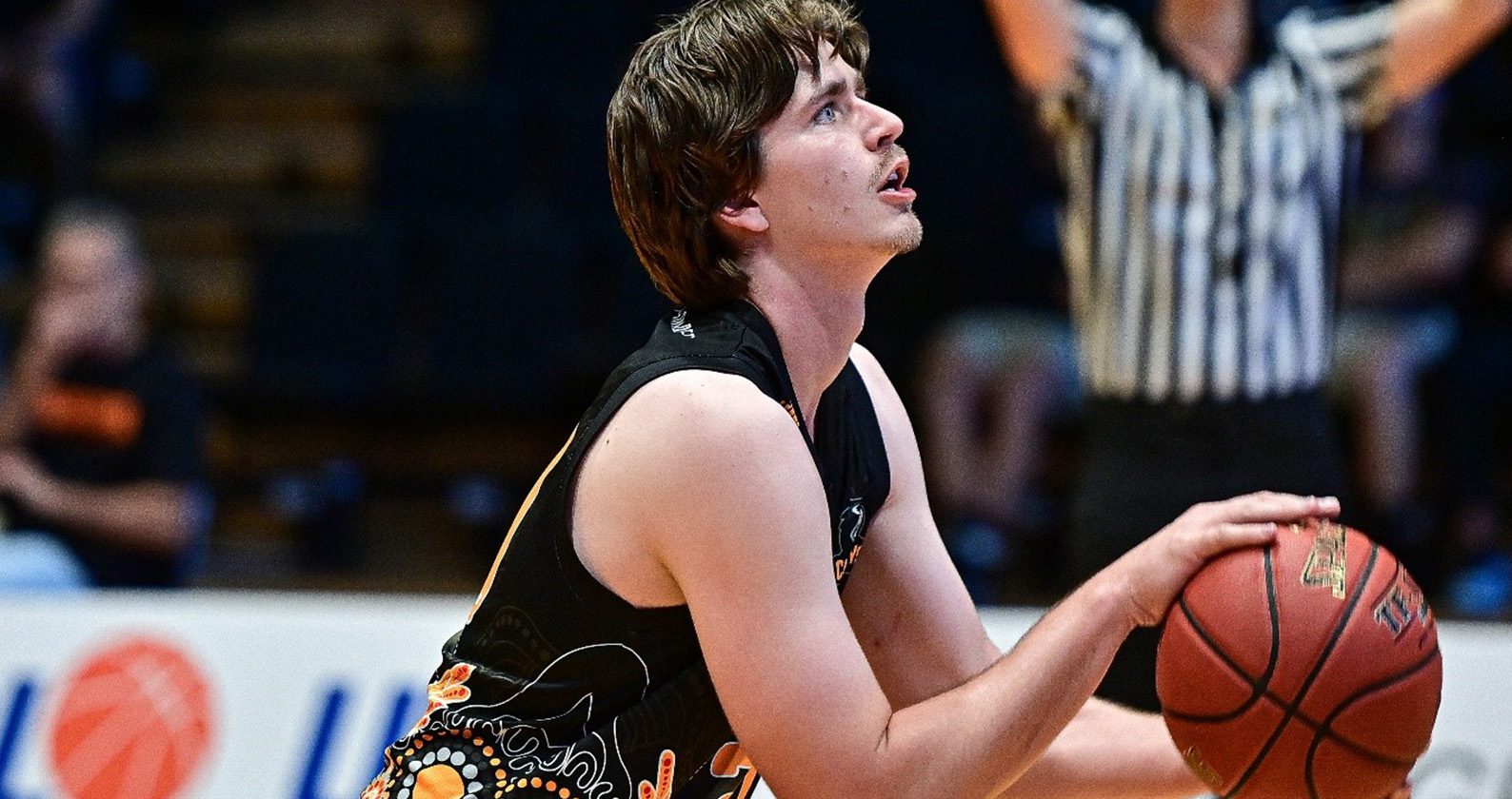 A male student basketball player preparing to score a goal.