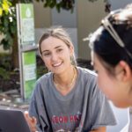 Two females talking together on campus