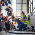 Female engineer working with robotic machine