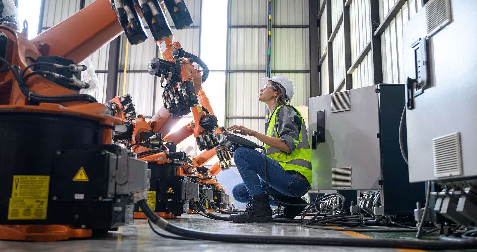 Female engineer working with robotic machine