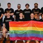 UBL men's team holding the Pride flag.