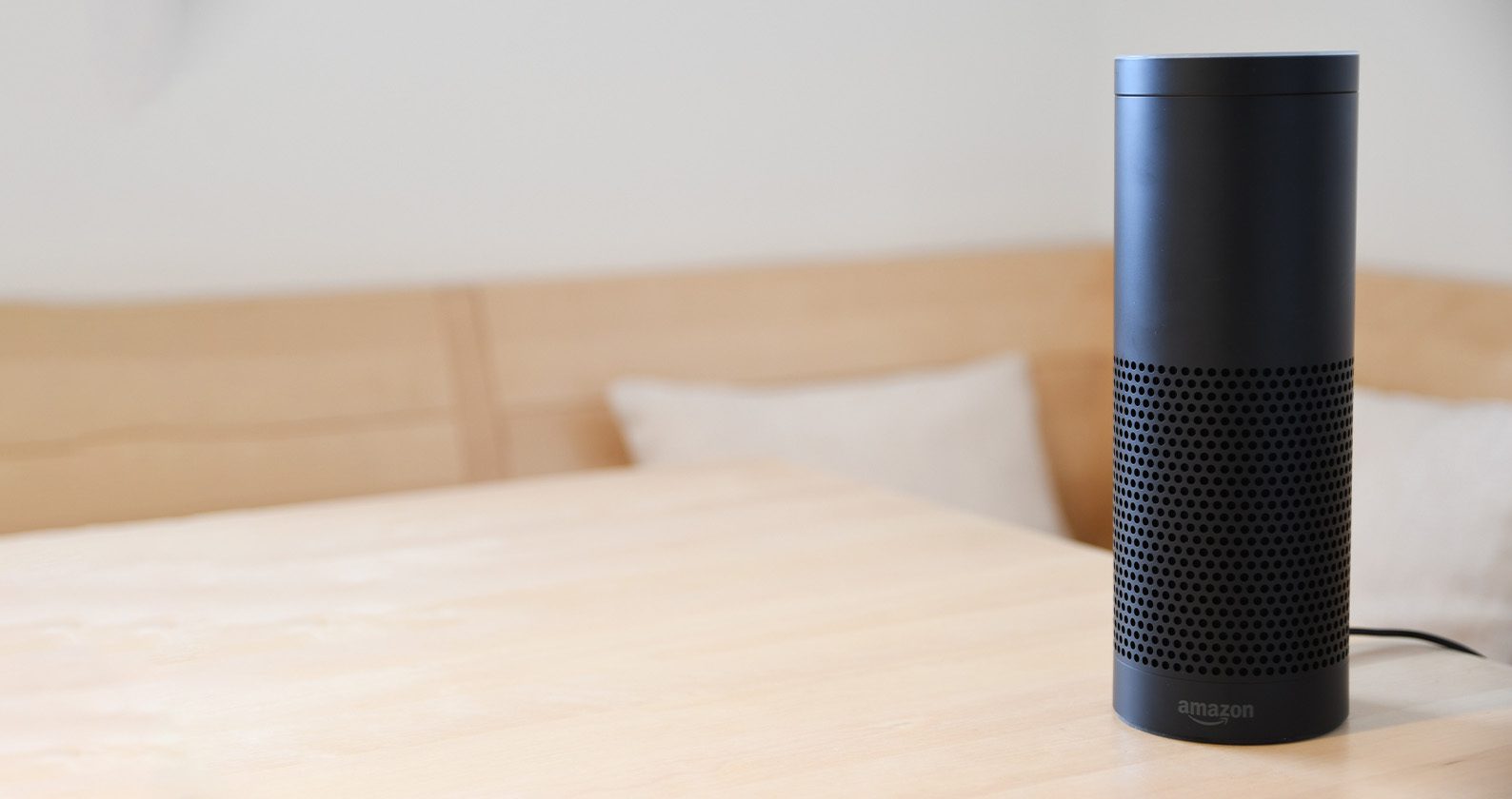 Amazon Alexa device on a wooden table.