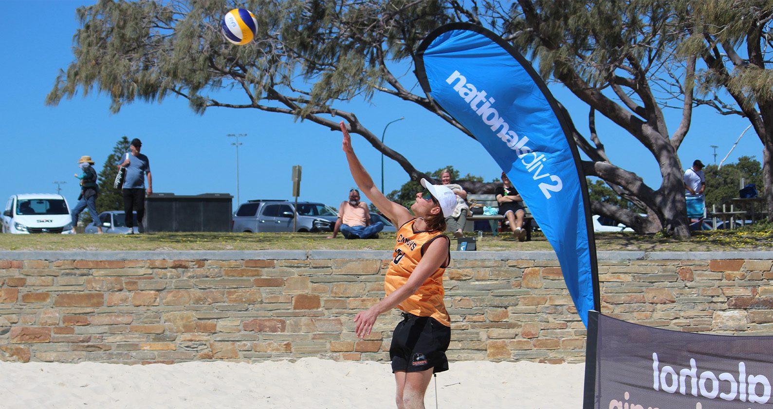 Student playing volleyball at a beach