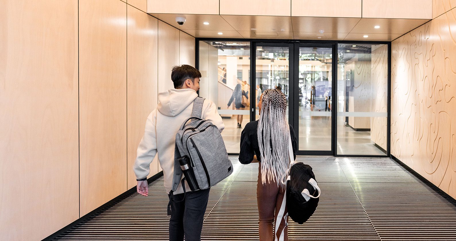 Two students walking into the TL Robertson Library
