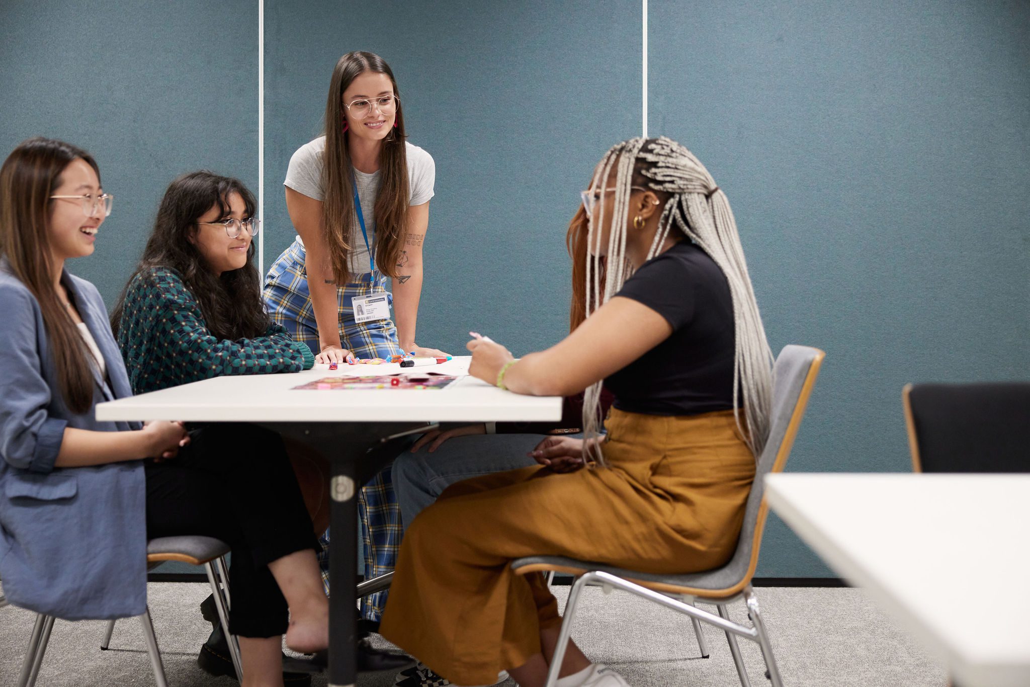 Students sitting around a desk talking together