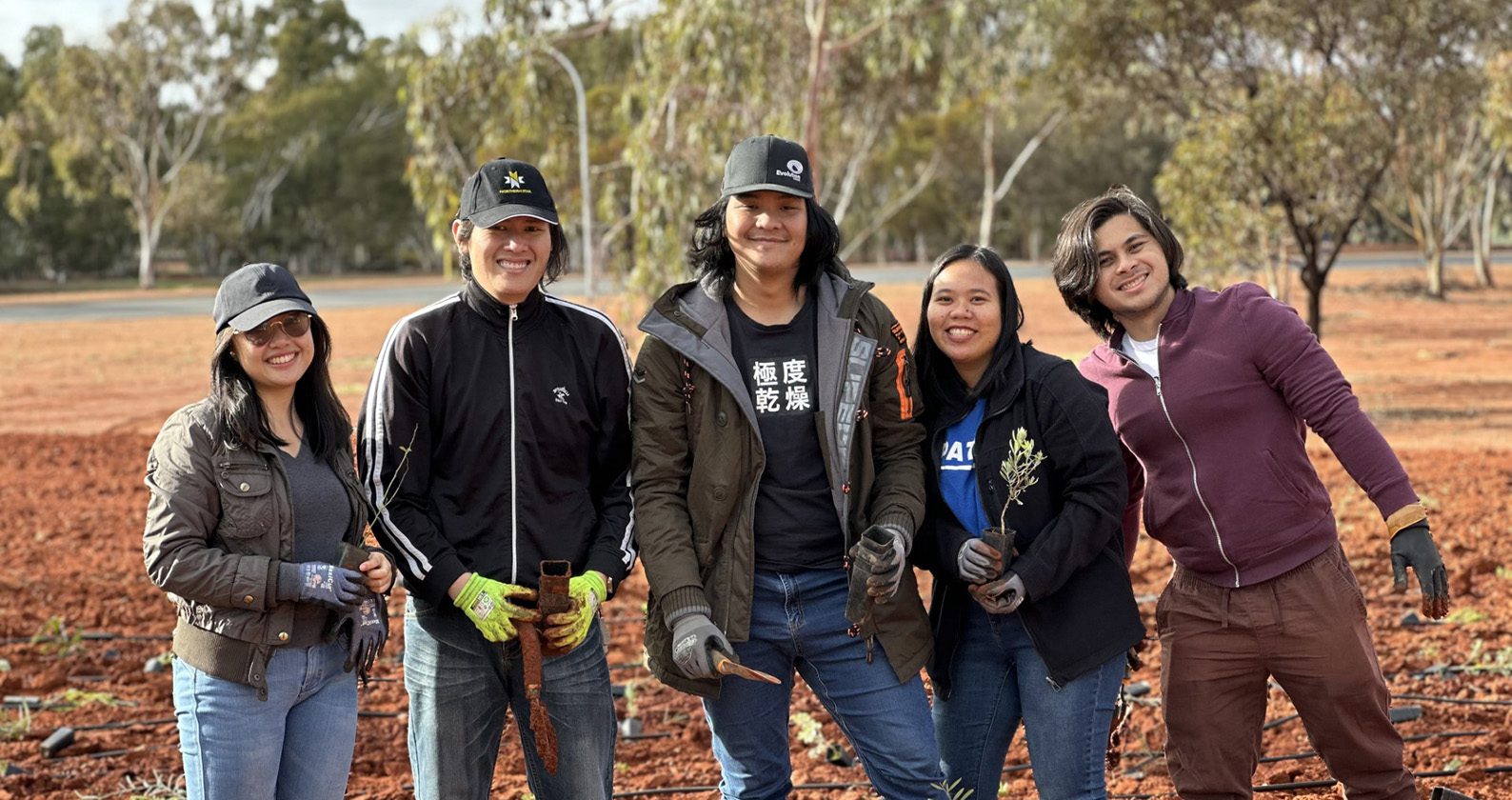 5 Curtin Kalgoorlie students smile at the camera during the Tree Planting event