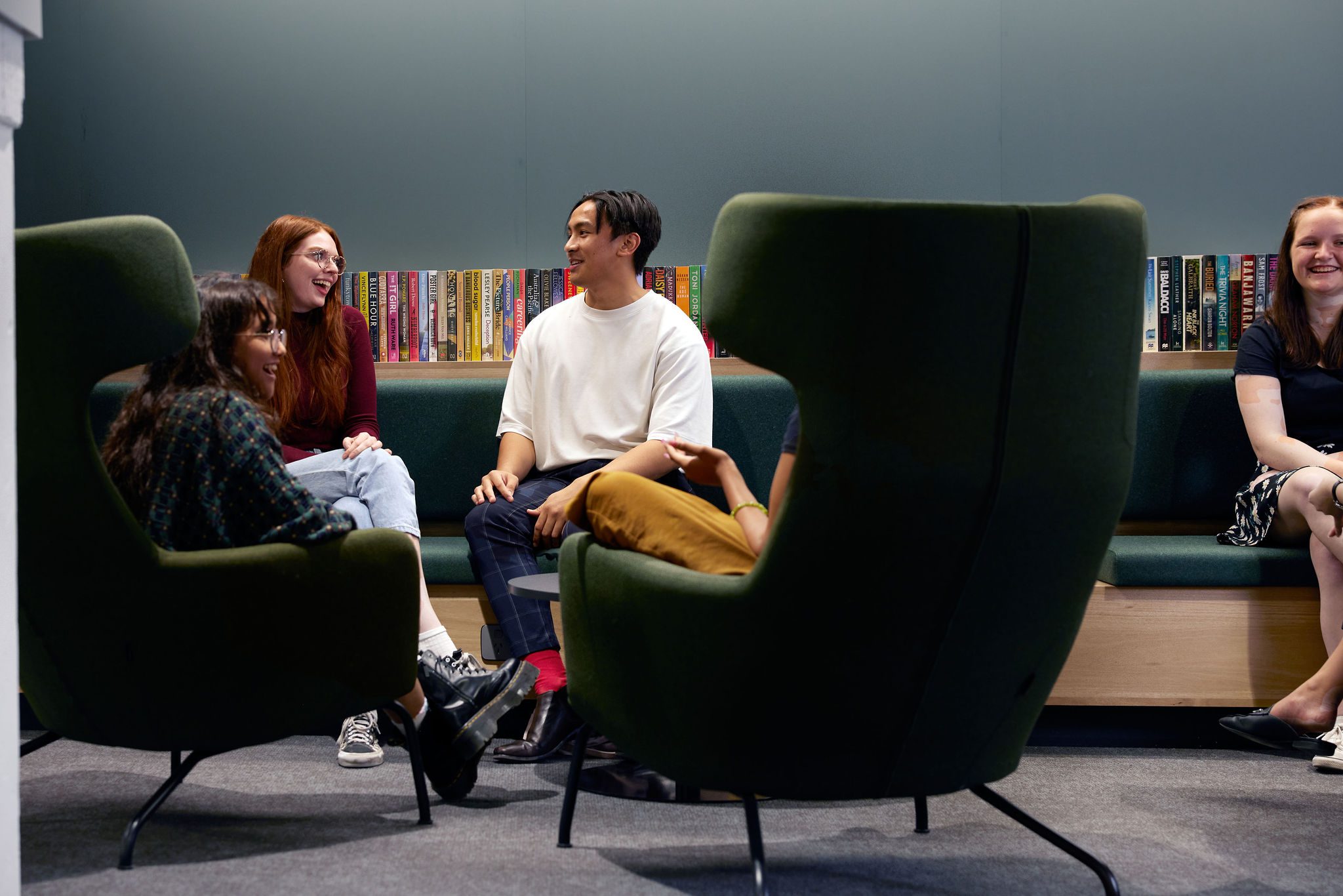 Students talking in a group on couches.