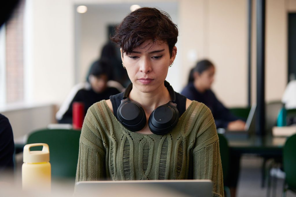 Student wearing a green jumper and headphones