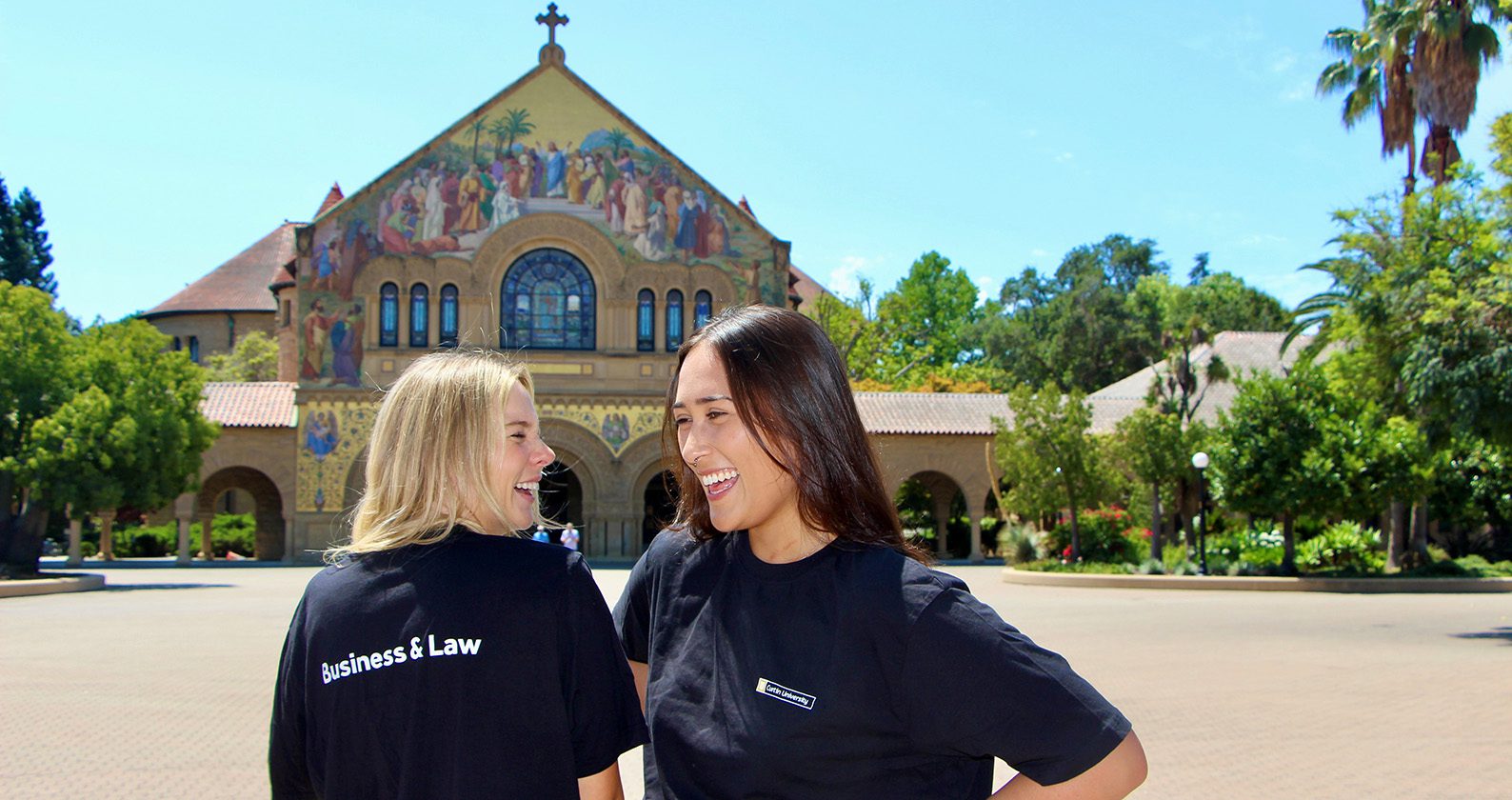 Two Business and Law students smiling and standing in front of a church.