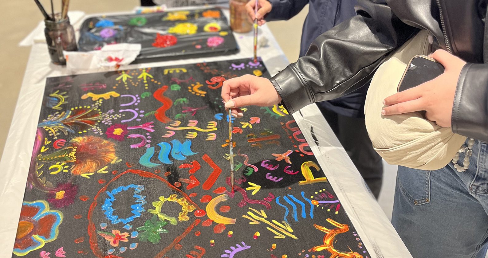 A close up view of students completing their collaborative artwork piece.