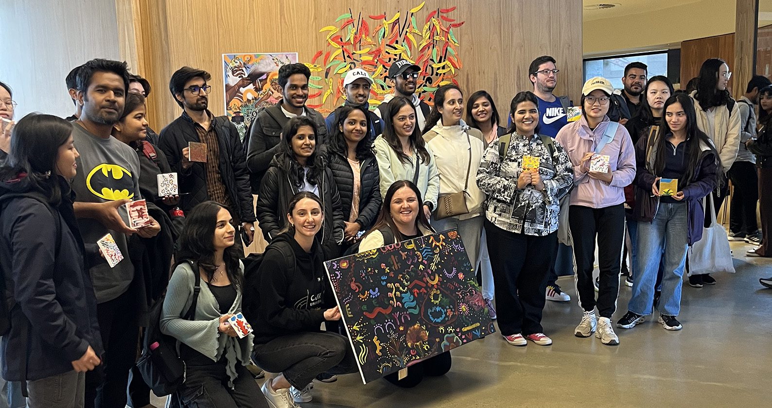 FBL International students take a group photo at Bilya Koort Boodja, holding their collective dot painting.